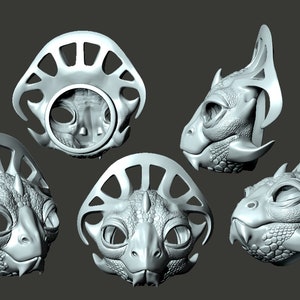 Könnte beinhalten: Fünf 3D-gedruckte Masken einer reptilienartigen Kreatur mit filigranen Details und einer strukturierten Oberfläche. Die Masken befinden sich in verschiedenen Posen und zeigen verschiedene Blickwinkel des Designs.