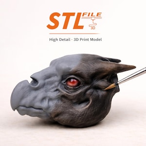 May include: A detailed 3D-printed model of a dragon's head, featuring a gray snout and a dark brown head. The dragon has a red eye and is being painted with a brush. The image includes the text "STL FILE 3D" and "High Detail 3D Print Model".