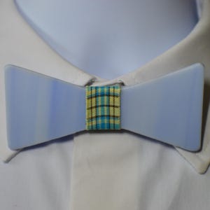 May include: A light blue bow tie with a yellow and blue plaid pattern in the centre.