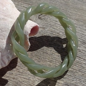 May include: A green jade bangle bracelet with a twisted rope design.