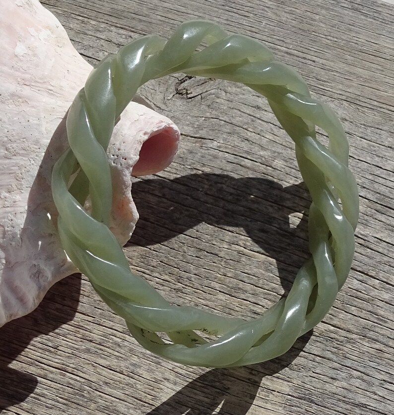 May include: A green jade bangle bracelet with a twisted rope design.