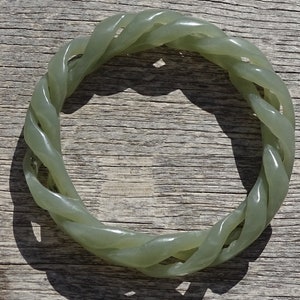 May include: A green jade bangle bracelet with a twisted rope design.
