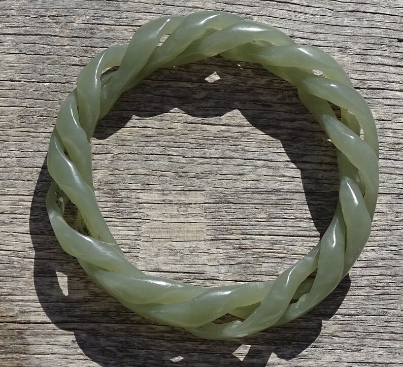 May include: A green jade bangle bracelet with a twisted rope design.