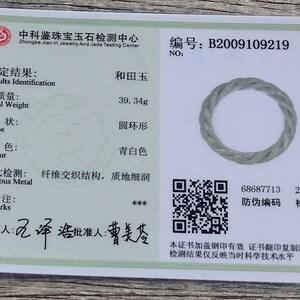May include: A jadeite jade ring with a twisted rope design. The ring is light green in color and has a smooth, polished finish. The certificate shows the ring is 39.34 grams and has a round shape. The certificate number is B2009109219. The certificate also includes a QR code and a date of 20200904.