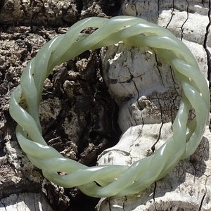 May include: A green jade bracelet with a twisted rope design.