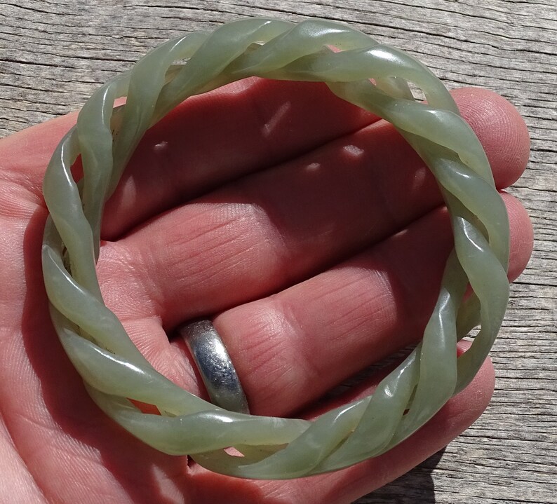 May include: A green jade bangle with a twisted rope design.