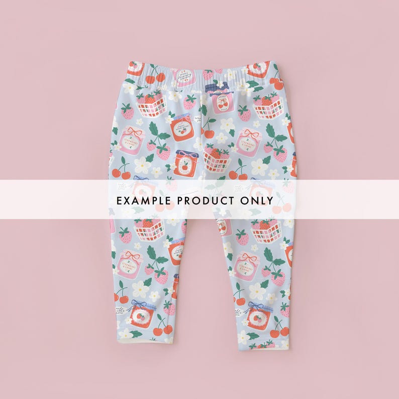 May include: Light blue leggings with an all-over pattern of strawberries, cherries, jam jars, and floral elements. The leggings have an elastic waistband and the text "EXAMPLE PRODUCT ONLY" across the center.