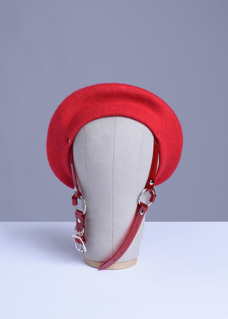Red wool beret with translucent red pvc harness straps and buckle