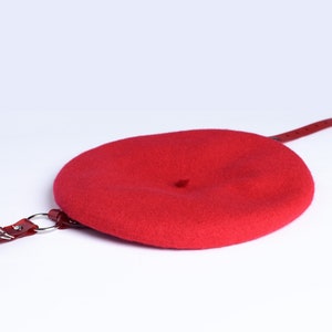 Red wool beret with translucent red pvc harness straps and buckle