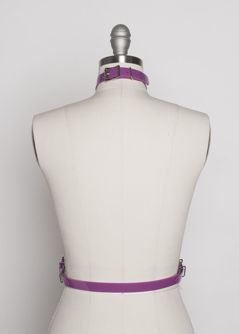 May include: A purple leather belt with a silver buckle. The belt is on a white mannequin.