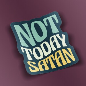 May include: A teal blue and yellow sticker with the text "NOT TODAY SATAN" in a stylized font.