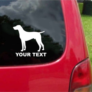 Op de afbeelding: Witte silhouet van een hond op een rood autovenster met de tekst "YOUR TEXT" eronder.