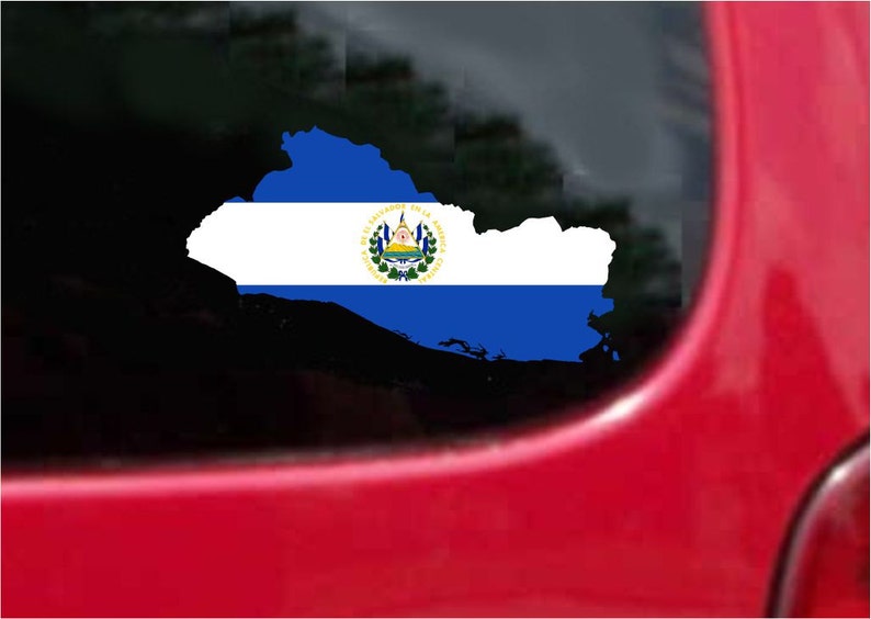 May include: A decal of El Salvador's map with the country's flag design. The flag features blue stripes, a white stripe with the national emblem, and is displayed on a car window. The background is a red car.