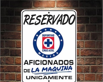May include: White sign with blue and black text that reads "Reservado", "Deportivo Cruz Azul Mexico", "Aficionados de la maquina unicamente". The sign features a blue and white circle with a red cross and the words "Deportivo Cruz Azul Mexico" inside.