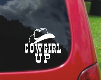 May include: White vinyl decal with a black cowboy hat and the text "COWGIRL UP" on a red car window.