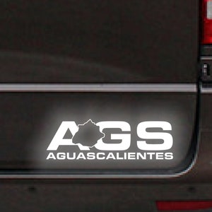 May include: White sticker on the back of a dark grey van with the text "AGS Aguascalientes".