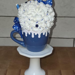 Back view of blueberry fake bake mug showing hand-placed sprinkles and faux blueberries on whipped cream topping for kitchen display.