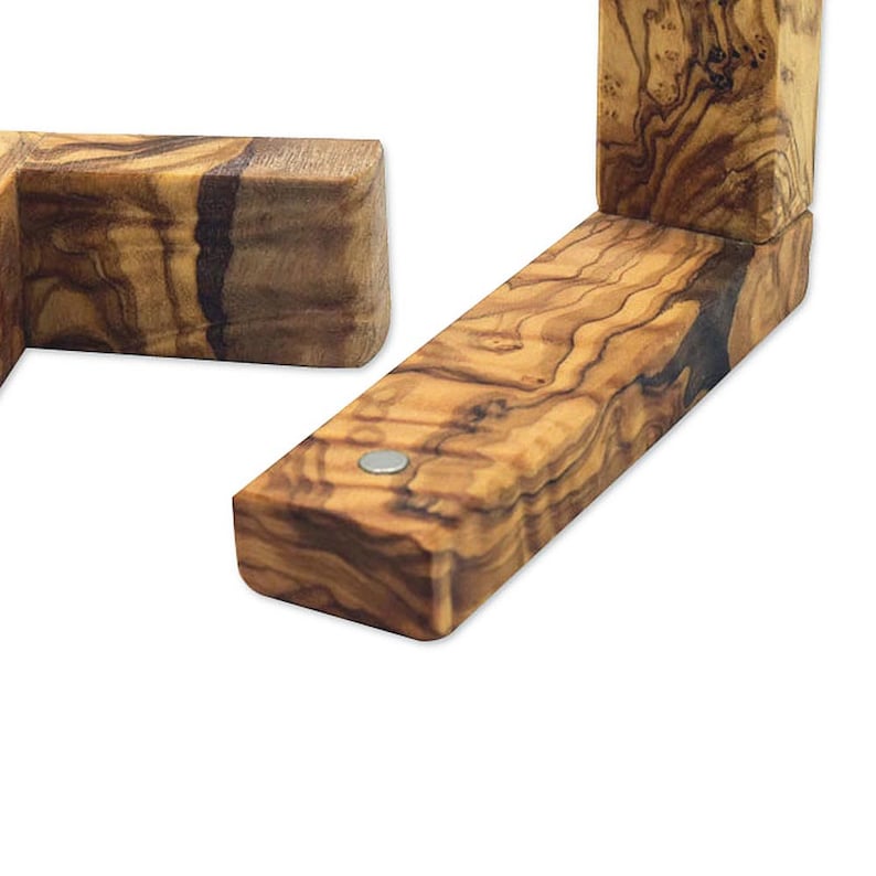 Puede incluir: Dos soportes de esquina de madera de olivo con un patr&oacute;n de veta de madera natural. Los soportes est&aacute;n conectados con una peque&ntilde;a pieza de metal.