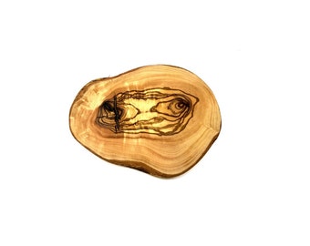 May include: A round wooden cutting board made from olive wood. The board has a natural wood grain pattern with dark brown streaks.