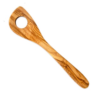 May include: Wooden olive wood slotted spoon with a round hole in the paddle. The spoon has a long handle and a natural wood grain pattern. Kitchen utensil for cooking and serving.