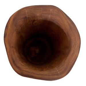 K&ouml;nnte beinhalten: Ein h&ouml;lzerner M&ouml;rser in dunkelbrauner Farbe mit einem glatten, abgerundeten Innenraum. Der M&ouml;rser besteht aus einem einzigen St&uuml;ck Holz und hat ein nat&uuml;rliches, rustikales Aussehen.