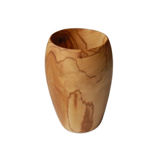 Può includere: Una tazza di legno realizzata in legno di ulivo. La tazza presenta un motivo a venature del legno naturale ed è di colore marrone chiaro.