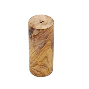 Puede incluir: Un salero de madera cilíndrico con un patrón de veta de madera natural y tres agujeros en la parte superior.
