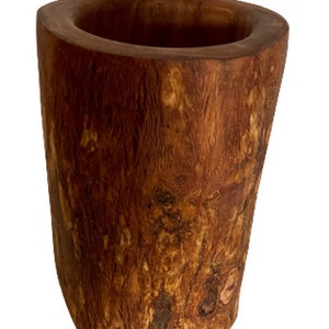 K&ouml;nnte beinhalten: Eine rustikale Holzvase mit nat&uuml;rlicher brauner Oberfl&auml;che. Die Vase besteht aus einem einzigen St&uuml;ck Holz und hat eine einzigartige, organische Form.