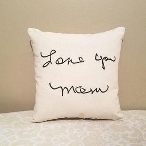 May include: White pillow with black handwritten text that says "Love you Mom".