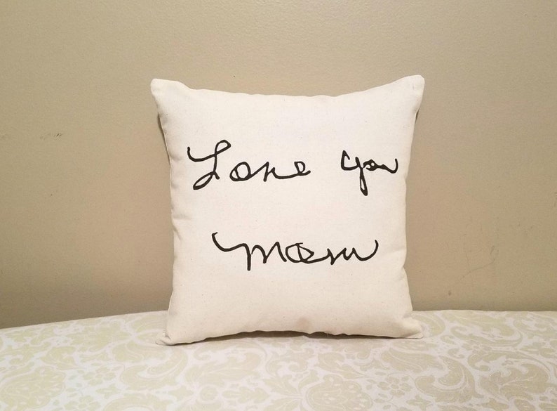 May include: White pillow with black handwritten text that says "Love you Mom".