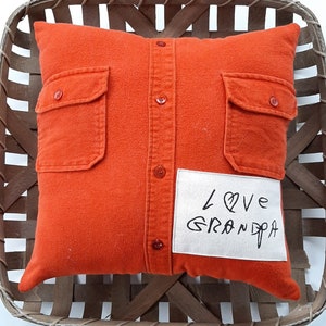May include: Orange pillow with a button-down shirt design and a white patch that says "Love Grandpa".