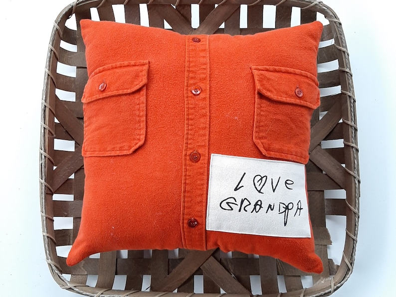 May include: Orange pillow with a button-down shirt design and a white patch that says "Love Grandpa".