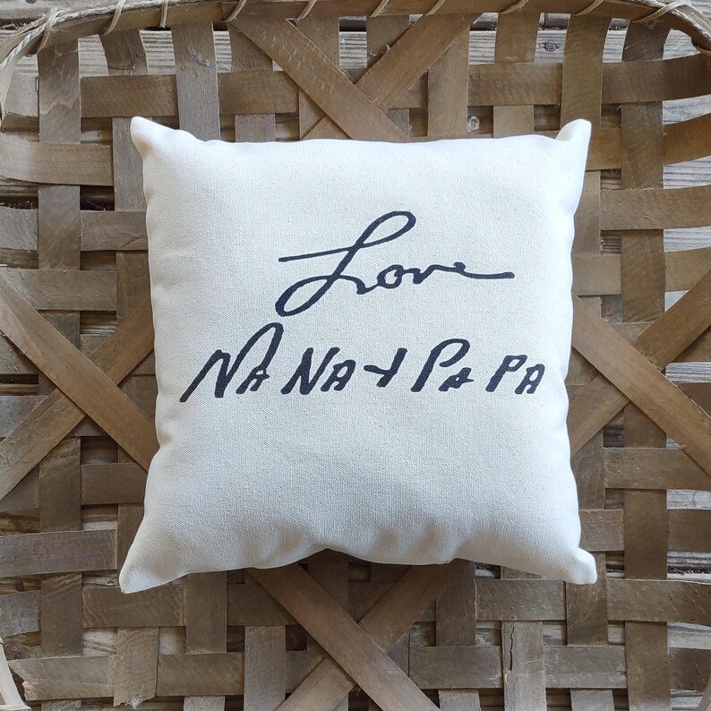 May include: A white pillow with black text that reads "Love from Na Na + Pa Pa".