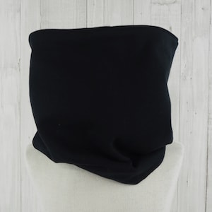 Op de afbeelding: Een zwarte fleece nekwarmer of nekgaiter. De nekwarmer is gemaakt van een zachte, rekbare stof en is ontworpen om je nek warm te houden bij koud weer.