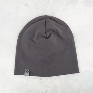 May include: A dark gray beanie with a small star logo on the side.