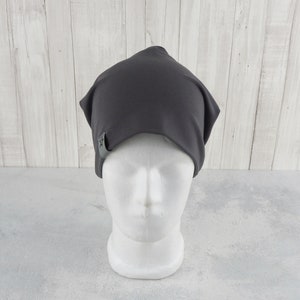 May include: A dark gray beanie with a small star logo on the side. The beanie is made of a soft, stretchy fabric and is perfect for keeping your head warm in the winter.