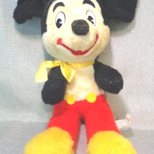 Puede incluir: Un juguete de peluche vintage de Mickey Mouse con orejas negras, un lazo amarillo, pantalones rojos y zapatos amarillos.