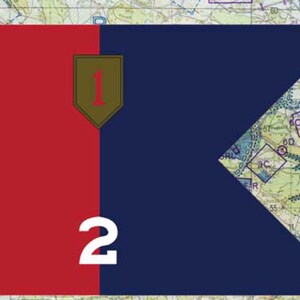 May include: A flag design with a red square on the left and a navy blue section on the right, featuring a white number 2. A shield with the number 1 is in the center. The background is a map.