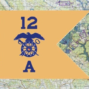 May include: A tan flag with the number "12" and the letter "A" in dark blue. The flag features a dark blue eagle above a wheel with a sword and a cannon. The background is a detailed map.