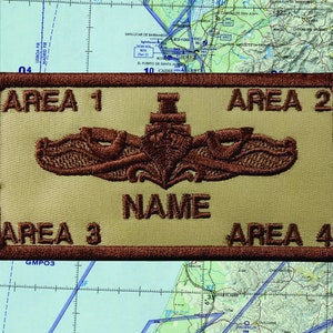 May include: Tan and brown embroidered patch with the text "AREA 1", "AREA 2", "AREA 3", and "AREA 4". The patch features a central emblem and the word "NAME".