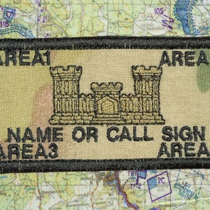 May include: Rectangular patch with black border, tan background, and embroidered design. The design includes a castle-like structure and text that reads "AREA1", "AREA2", "NAME OR CALL SIGN", "AREA3", and "AREA4". The patch is set against a map background.