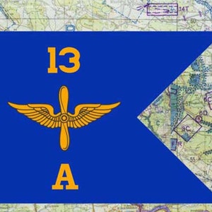 May include: A blue flag with the text "13 A" in yellow, along with a yellow propeller and wing design. The flag is set against a map background, with various markings and text.