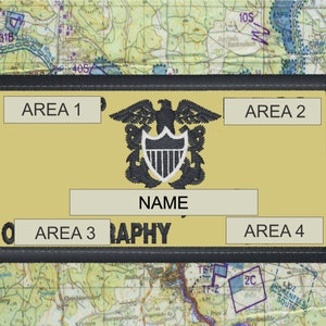 May include: A rectangular patch with a gold background and a black border. The patch features an embroidered eagle and shield emblem, with text fields labeled "AREA 1", "AREA 2", "AREA 3", "AREA 4", and "NAME". The patch is set against a map background.