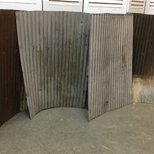 May include: Four corrugated metal panels, two are rusty brown, and two are a weathered gray. The panels are arranged in a semi-circle.