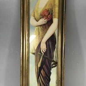 May include: A vertical rectangular framed print featuring a portrait of a person with dark hair wearing a gold top and a long dark purple skirt. The person holds a bouquet of red flowers and a small fan, wearing a headband and light-colored shoes.