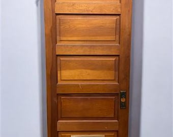 May include: A solid wood door with five raised panels and a metal vent at the bottom. The door is painted a light brown color.