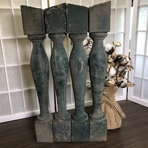 Puede incluir: Cuatro balaustres de madera antiguos con un acabado de pintura verde oscuro. Los balaustres están desgastados y tienen un aspecto rústico.