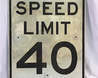 Peut inclure: Un panneau de limitation de vitesse en métal argenté avec du texte et des chiffres noirs. Le panneau indique "SPEED LIMIT 40".