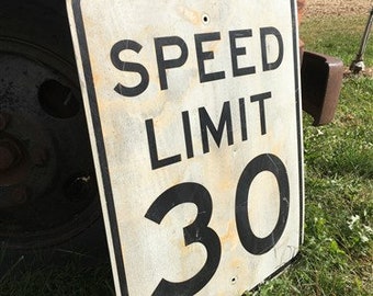 Peut inclure: Un panneau de limitation de vitesse en métal blanc avec du texte et des chiffres noirs. Le panneau indique "SPEED LIMIT 30".