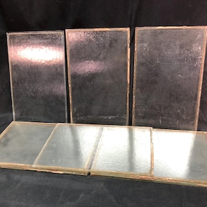 Puede incluir: Seis piezas rectangulares de vidrio con una superficie texturizada. El vidrio es transparente y tiene un ligero tono verde. El vidrio está dispuesto en dos filas de tres.